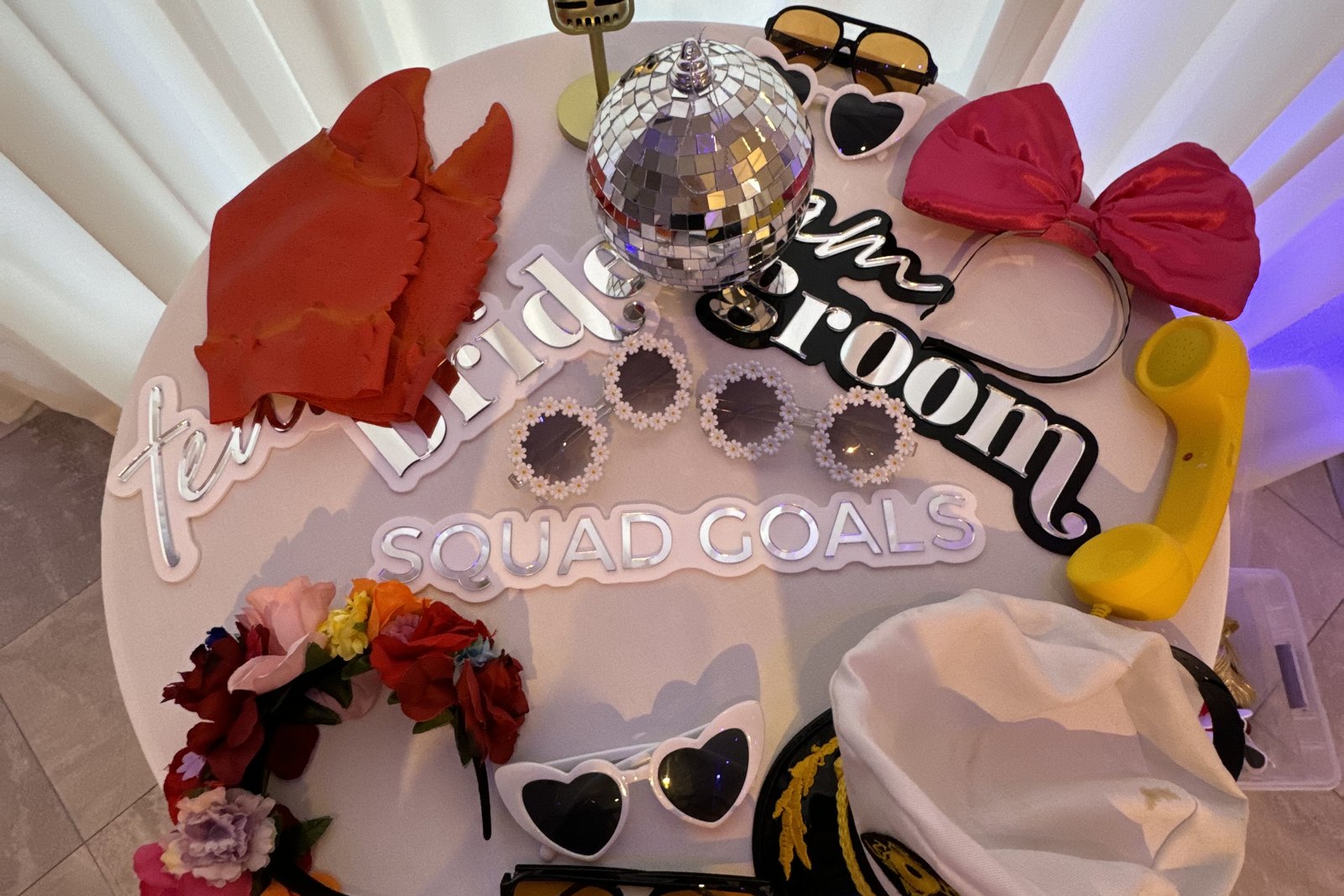 A table laid out with props and prints beside the booth